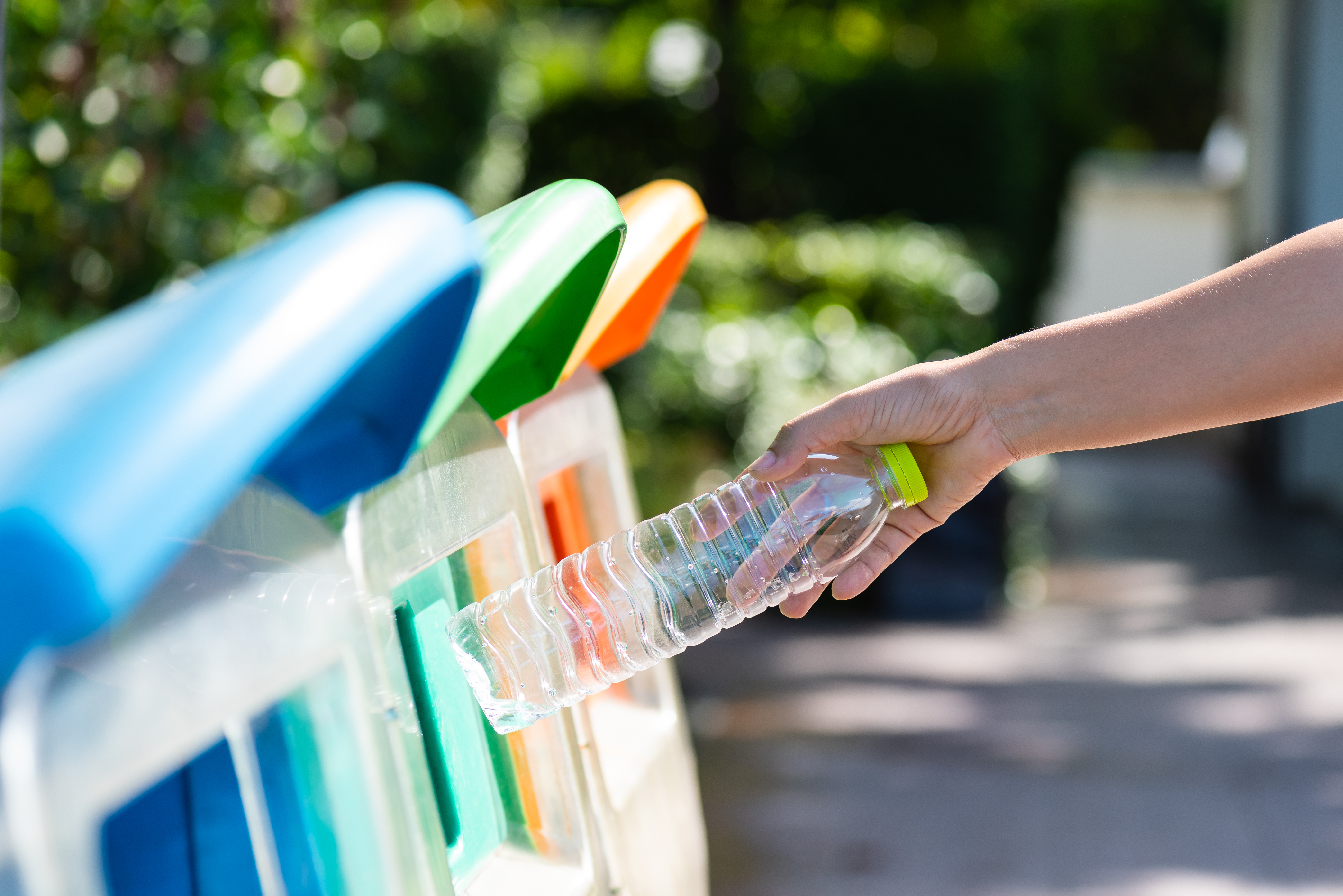 World Environment Day, June 5. Woman hand holding and putting plastic bottle waste into garbage trash.